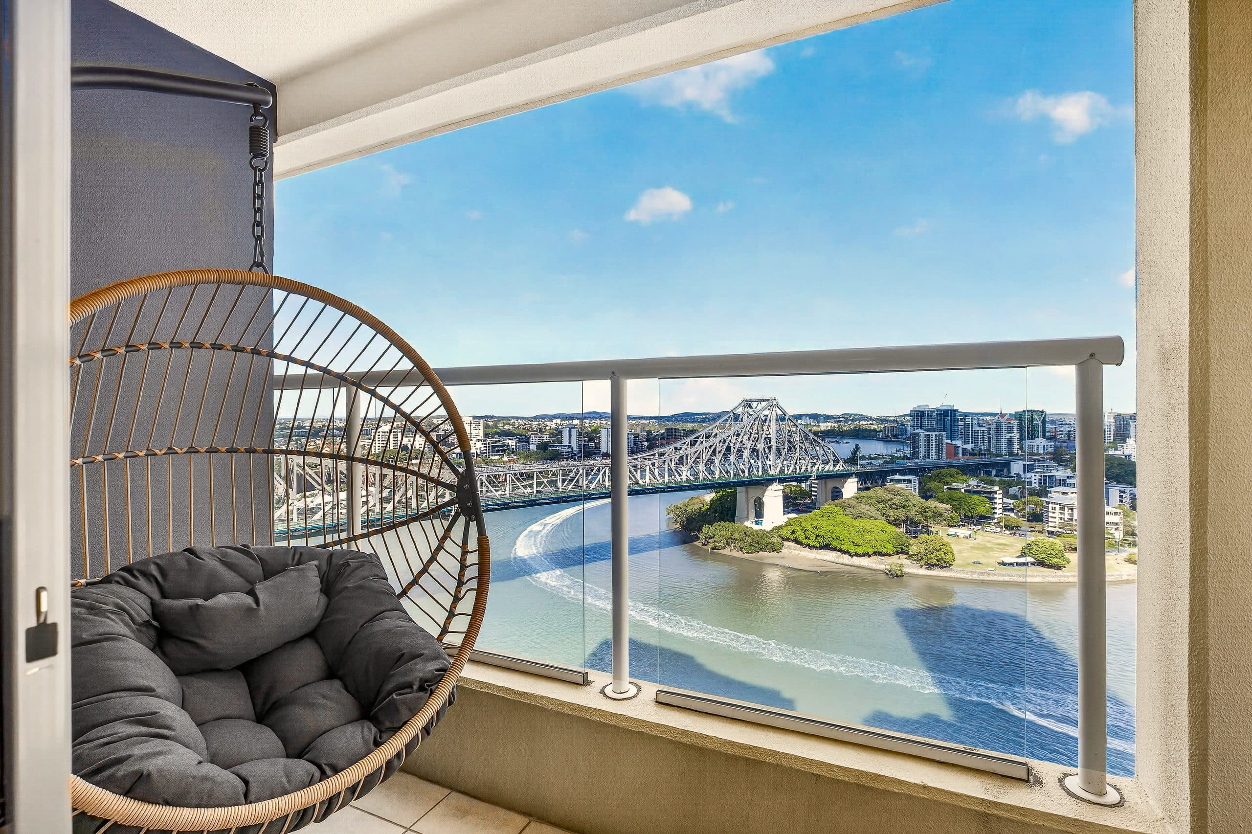 Egg chair on a Brisbane apartment balcony overlooking the Story Bridge
